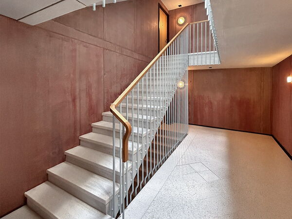 steintreppe mit weissem stahltreppengeländer und holzhandlauf